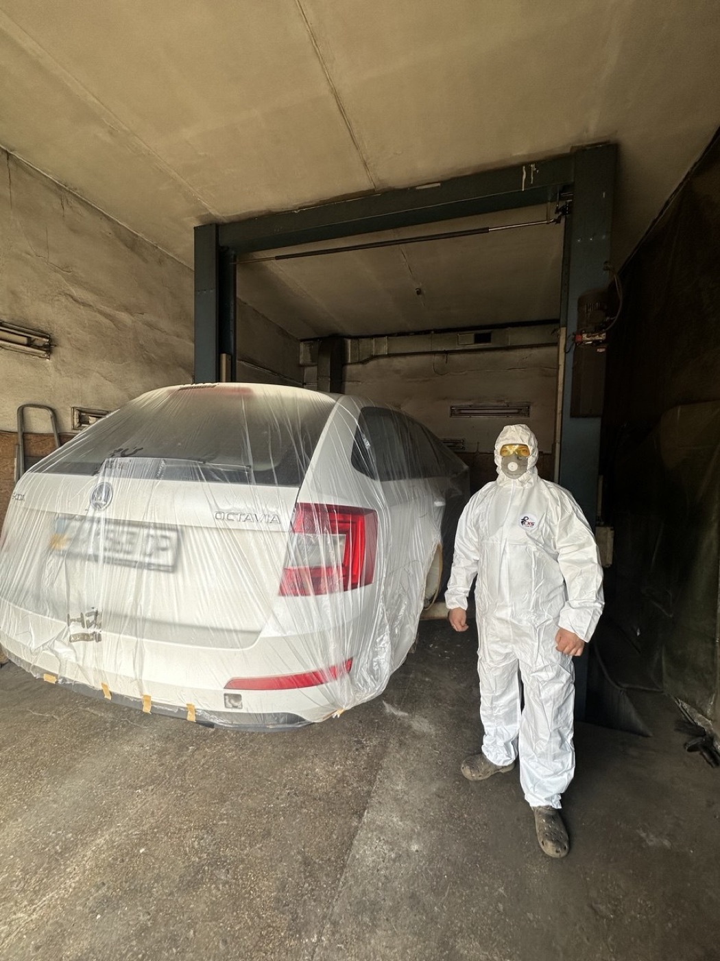 Майстер у захисному костюмі готує авто до антикорозійної обробки